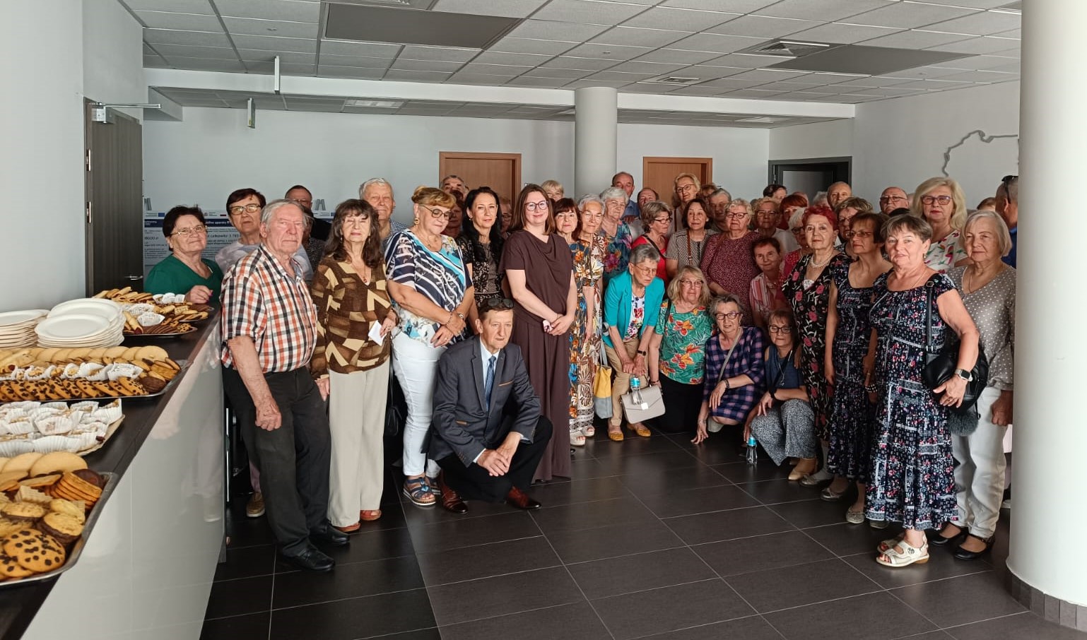 Uczestnicy Wirtualnego Klubu Seniora. Zdjęcie grupowe przed aulą WSzS.