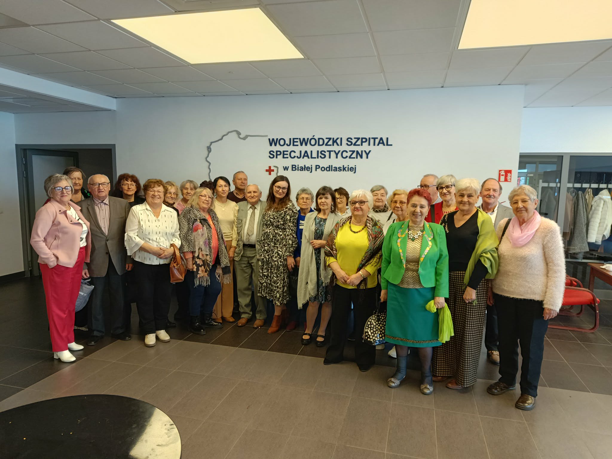 Uczestnicy Wirtualnego Klubu Seniora. Zdjęcie grupowe przed aulą WSzS.